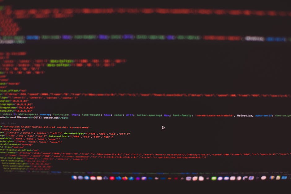 A close-up photograph of a computer screen displaying lines of colorful HTML and CSS code on a dark background. The code is presented in multiple colors including red, green, blue, and purple, indicat